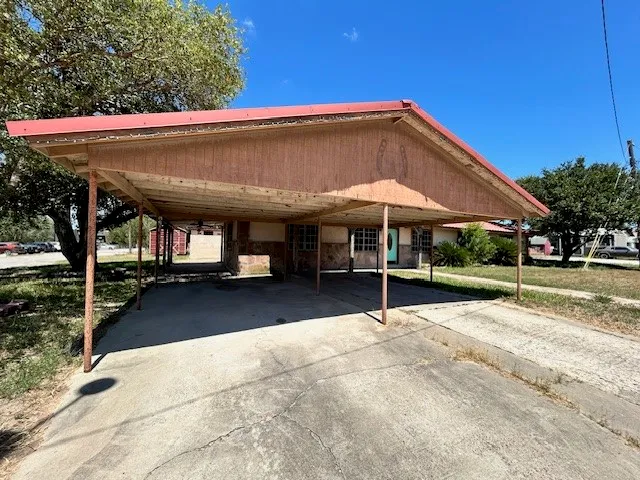 a view of patio with a table and chairs under an umbrella