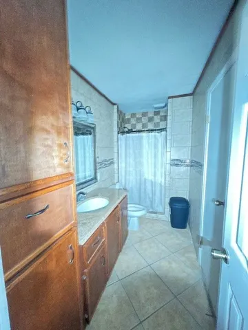 a bathroom with a granite countertop sink a toilet a mirror and vanity