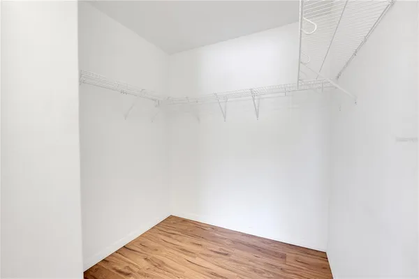a view of a room with a ceiling fan and hardwood floor