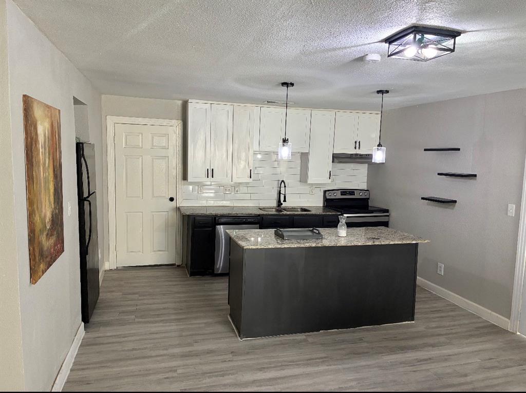 109 Lydia Street Terrell, TX 75160 - Photo 14 of 15 a kitchen with kitchen island stainless steel appliances a sink cabinets and wooden floor