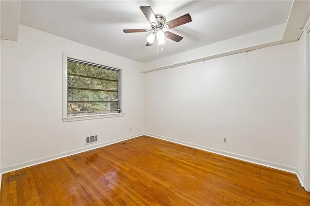 wooden floor in an empty room with a window