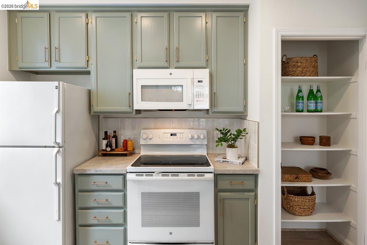 2029 Channing Way, Unit 3D Berkeley, CA 94704 - Photo 23 of 54 Kitchen featuring sage green cabinetry with gold-tone hardware, white appliances, and a light-toned countertop