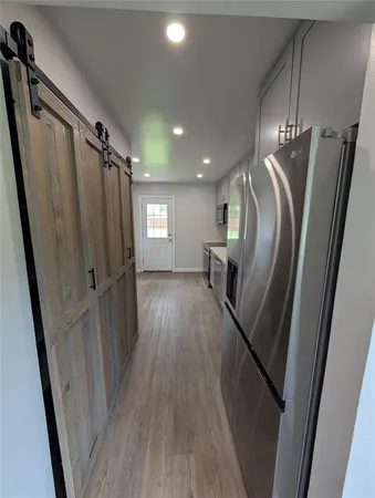 a kitchen with stainless steel appliances a stove a microwave a sink and cabinets