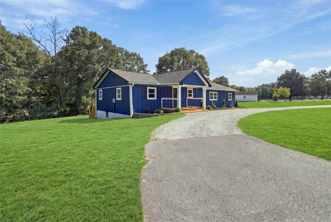 418 Old River Road Pelzer, SC 29669 - Photo 2 of 32 A long private driveway curves toward this charming single-level home set on a sprawling lawn.