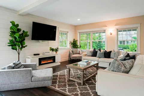 a living room with furniture a large window and a flat screen tv