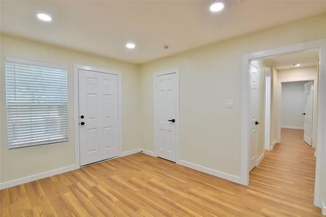 a view of an empty room with wooden floor