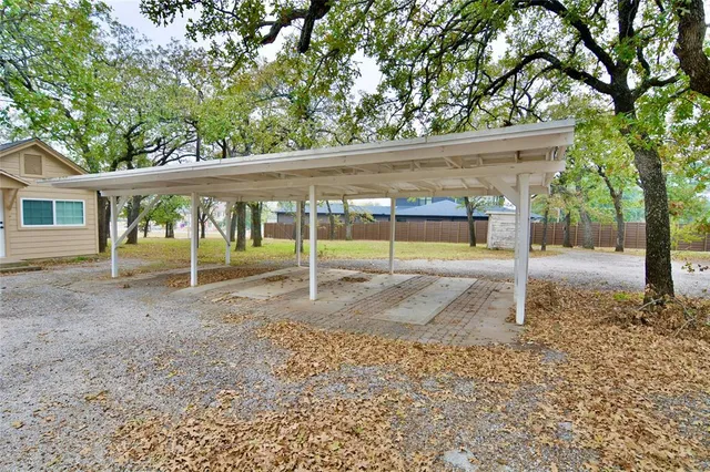 a view of a house with a yard and large tree