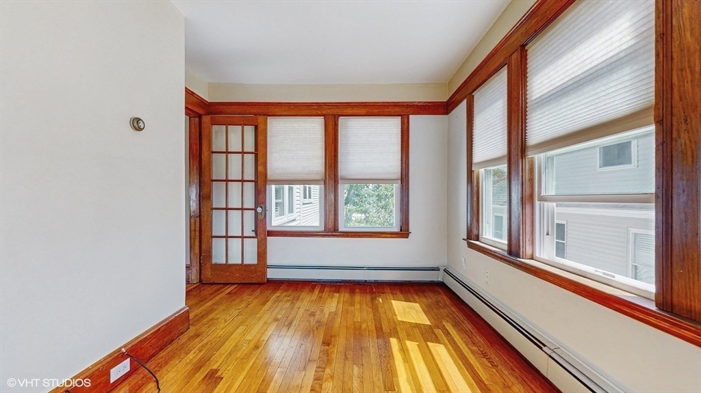 68 Bradford Road Watertown, MA 02472 - Photo 29 of 42 a view of an empty room with a window and wooden floor