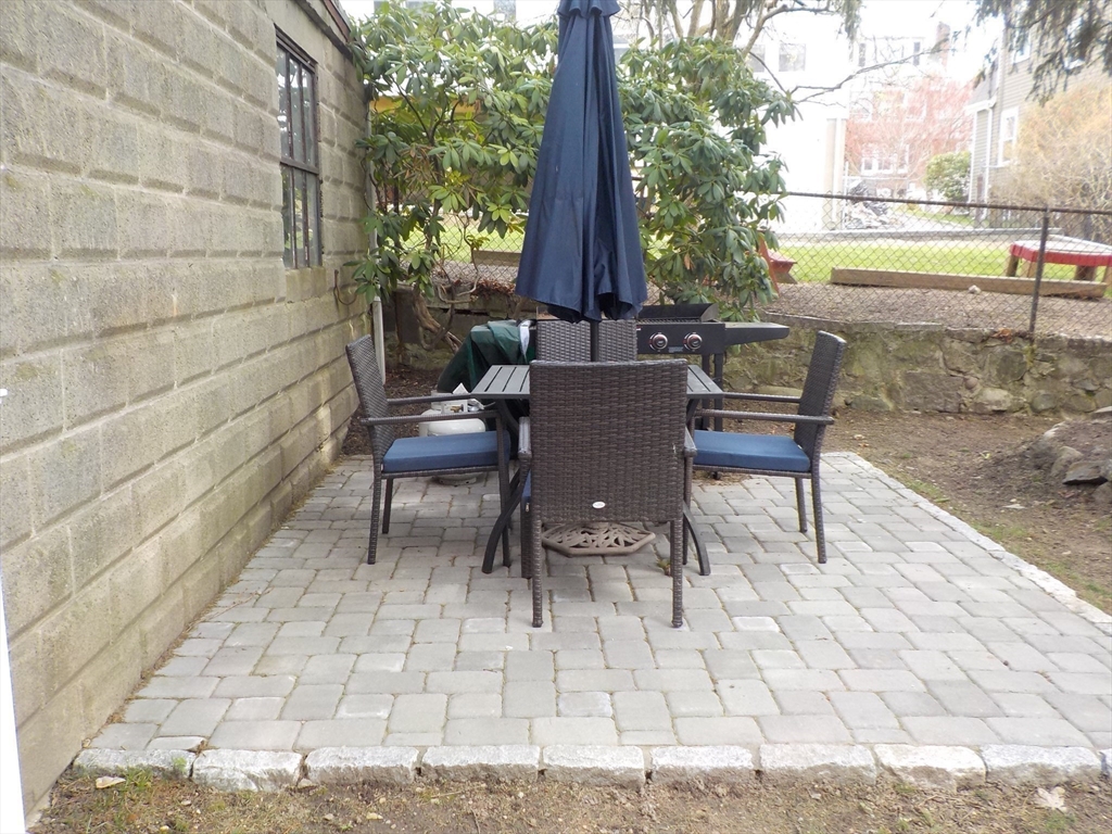 68 Bradford Road Watertown, MA 02472 - Photo 7 of 42 a view of a patio with a table and chairs
