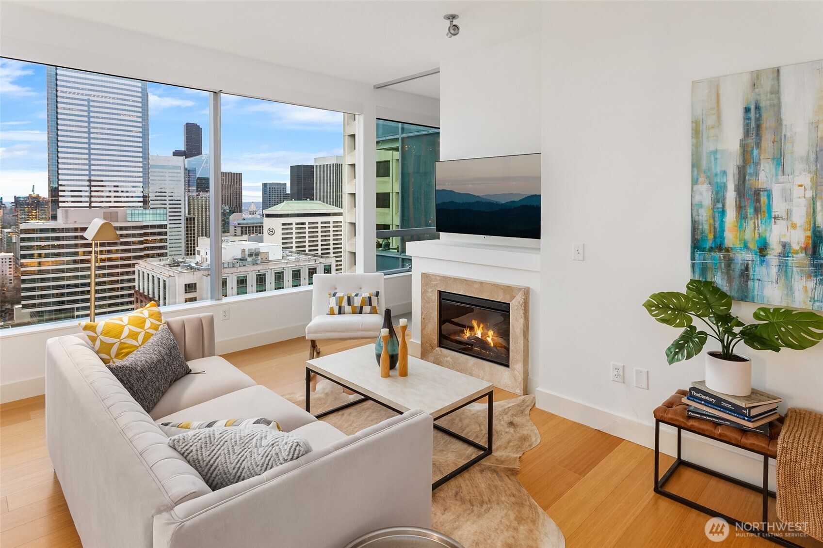 737 Olive Way, Unit 2905 Seattle, WA 98101 - Photo 11 of 38 a living room with furniture a flat screen tv and a fireplace