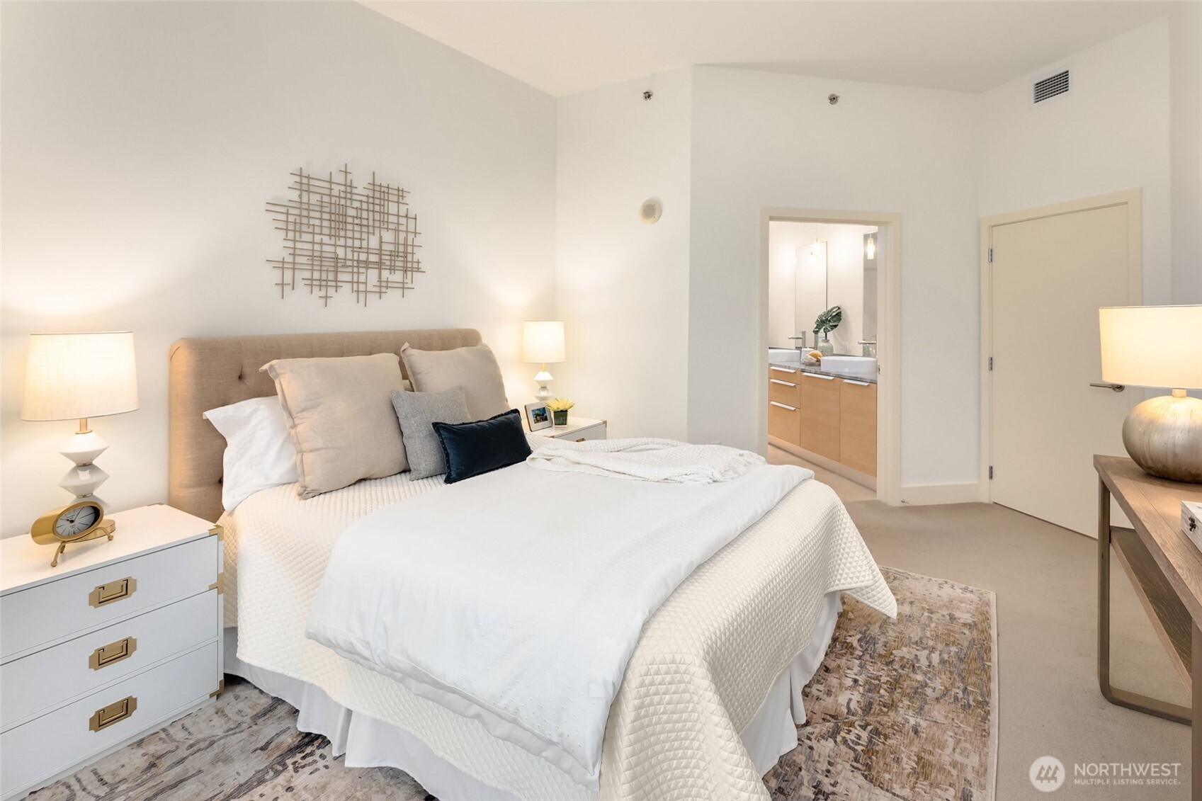 737 Olive Way, Unit 2905 Seattle, WA 98101 - Photo 18 of 38 a spacious bedroom with a bed and a lamp on dresser