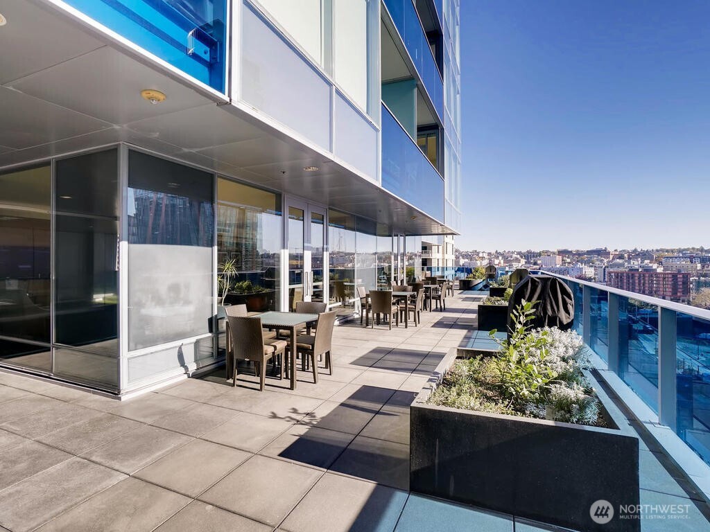 737 Olive Way, Unit 2905 Seattle, WA 98101 - Photo 32 of 38 a view of a patio with a dining table and chairs