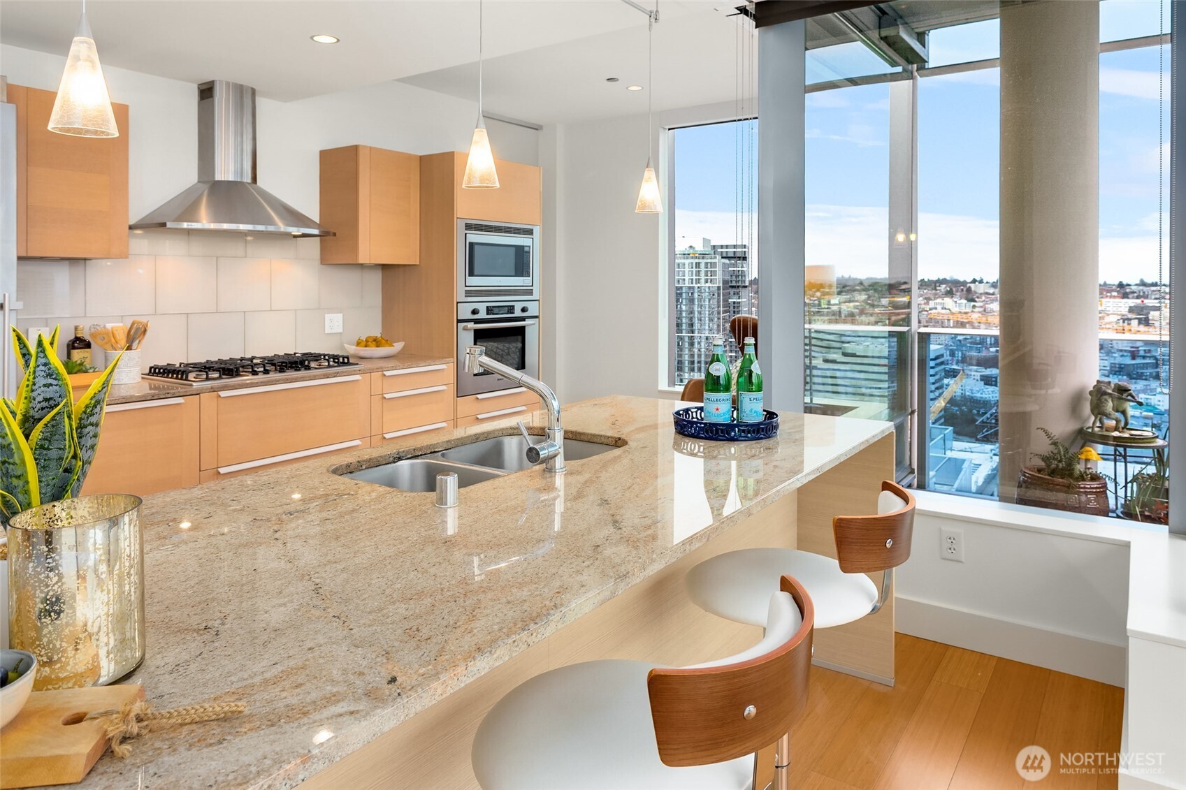 737 Olive Way, Unit 2905 Seattle, WA 98101 - Photo 10 of 38 a kitchen with stainless steel appliances granite countertop a sink a stove and white cabinets next to a window