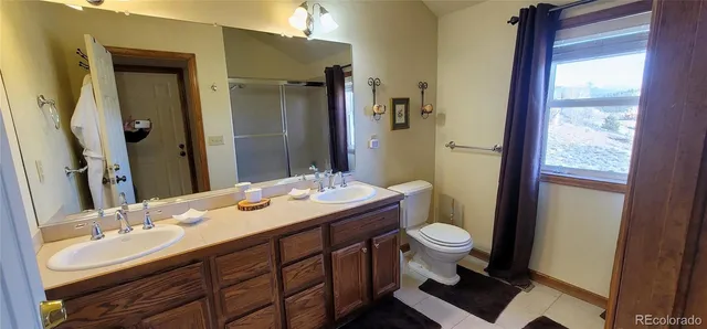 a bathroom with a sink a toilet a mirror and shower