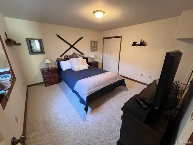 a bedroom with a bed and a flat tv screen on the dresser