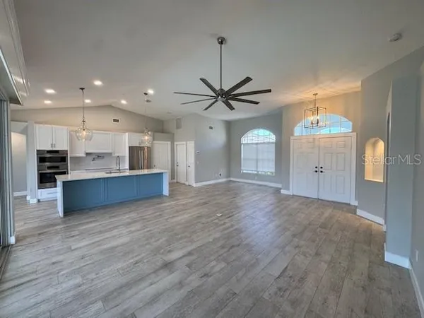 a kitchen with kitchen island a counter top space a sink stainless steel appliances and cabinets