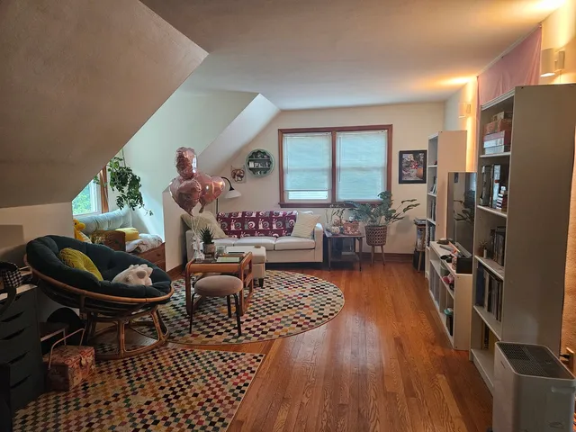 a living room with furniture a wooden floor and a large window