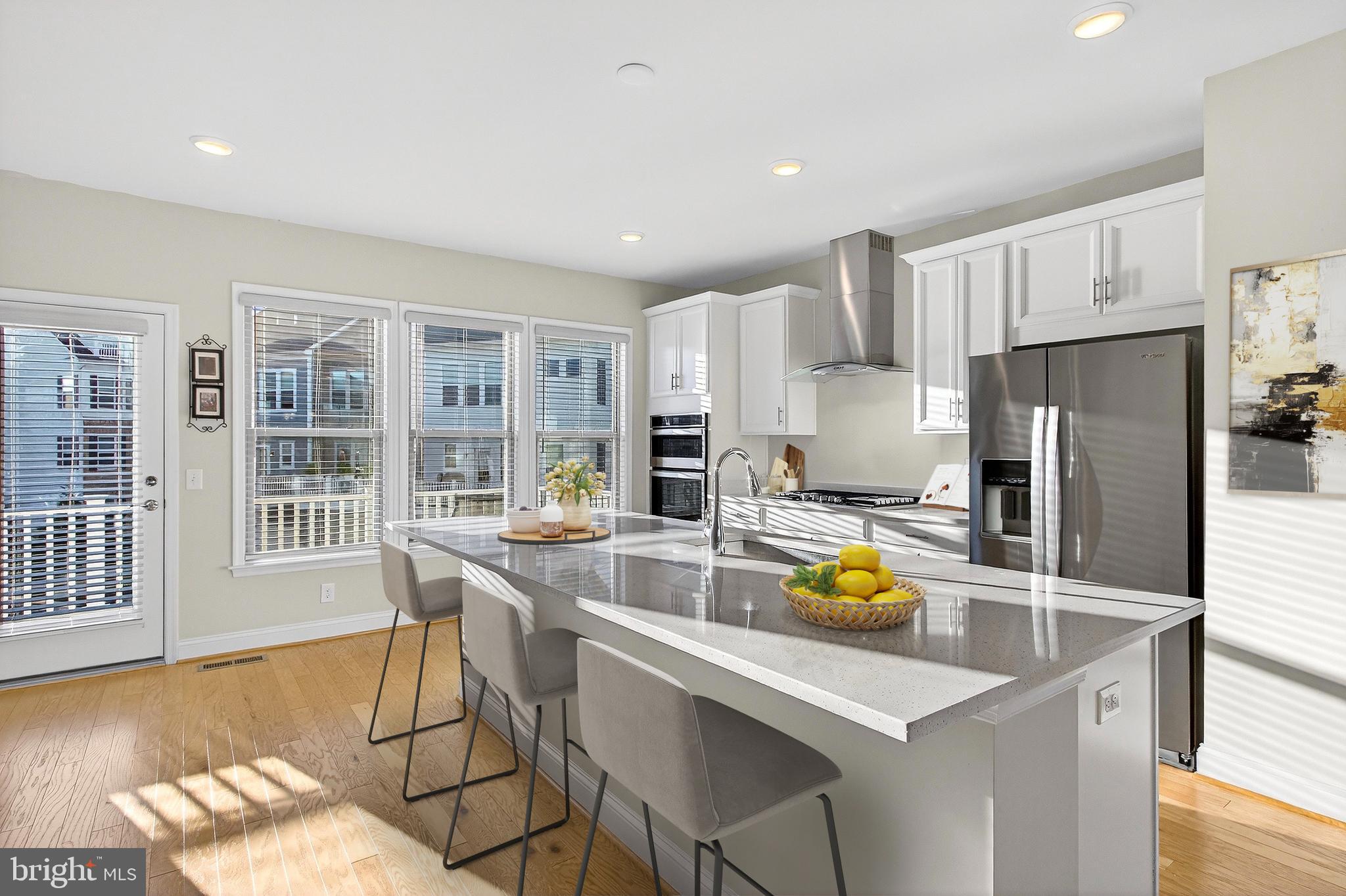 17161 Branched Oak Road Dumfries, VA 22026 - Photo 7 of 28 a kitchen with a refrigerator a stove a sink dishwasher and white cabinets with wooden floor