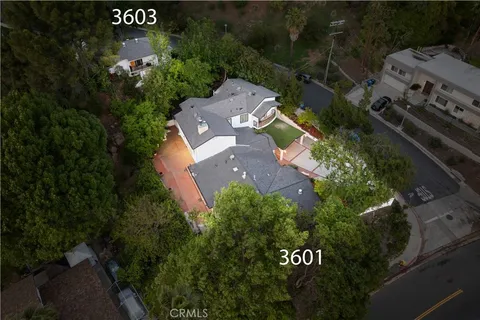 an aerial view of a house with garden space and street view