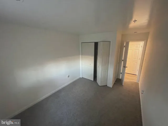 an empty room with closet and windows