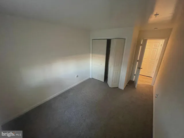 an empty room with a hallway and closet