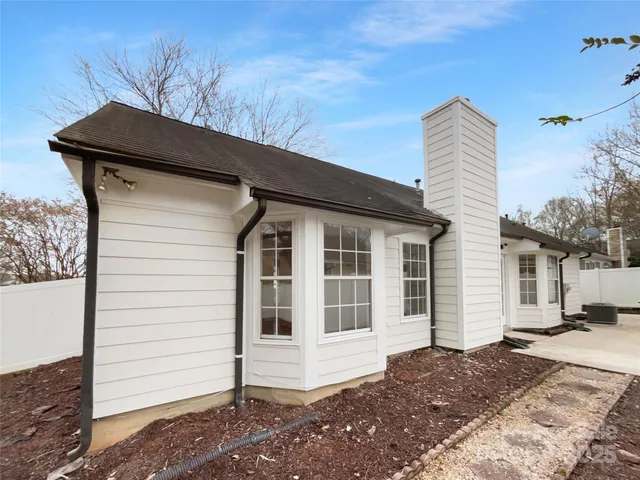 a view of a house with a door and wooden fence