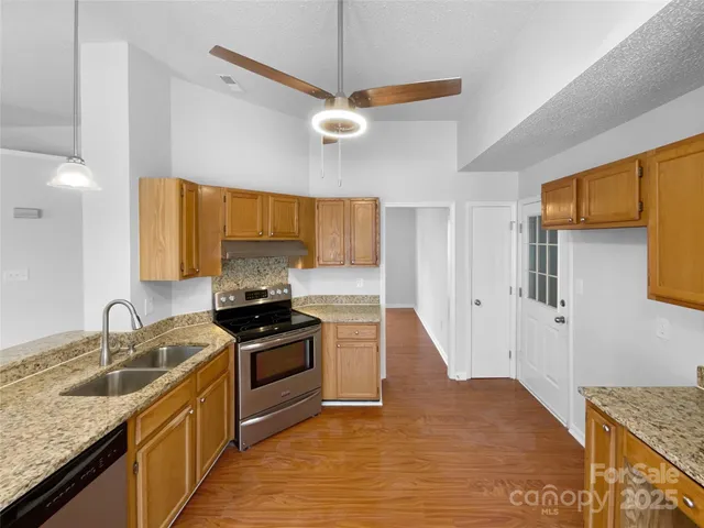 a kitchen with granite countertop a sink stainless steel appliances and cabinets