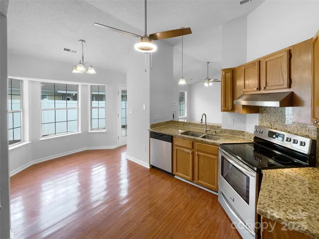 a kitchen with stainless steel appliances granite countertop a stove a sink and a refrigerator