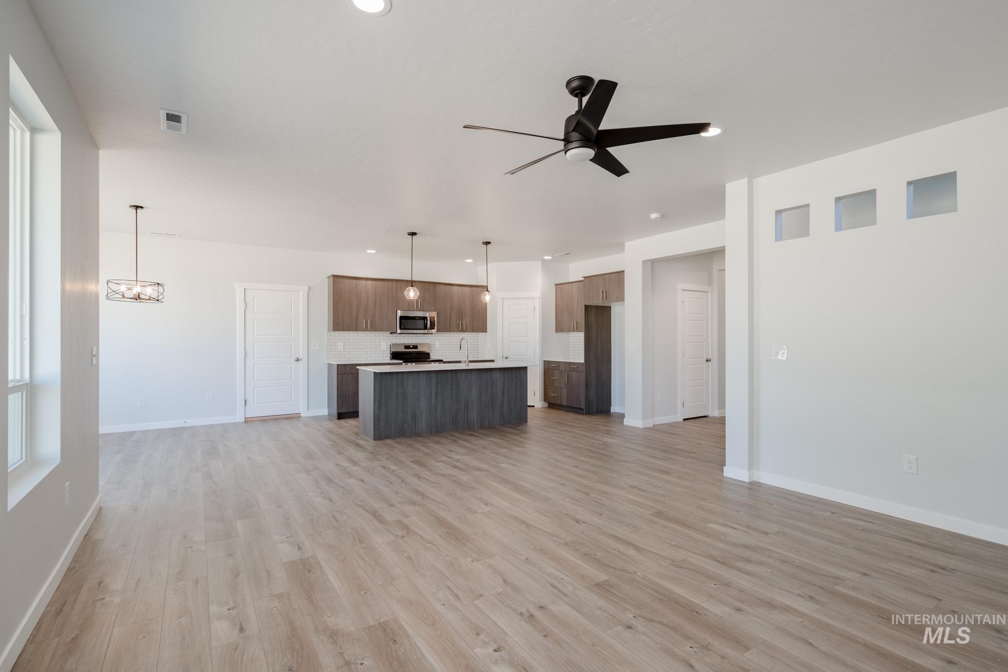5304 Castleton Avenue Nampa, ID 83686 - Photo 14 of 25 Unfurnished living room featuring light wood-style floors, ceiling fan, recessed lighting, and a chandelier