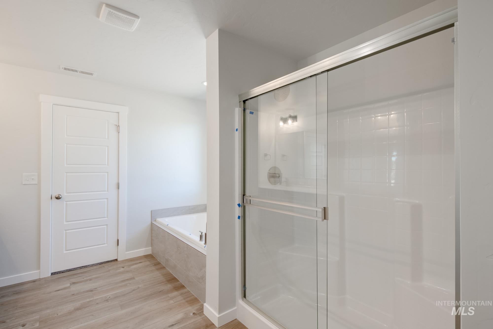 5304 Castleton Avenue Nampa, ID 83686 - Photo 20 of 25 Bathroom with a garden tub, a shower stall, and light wood-type flooring