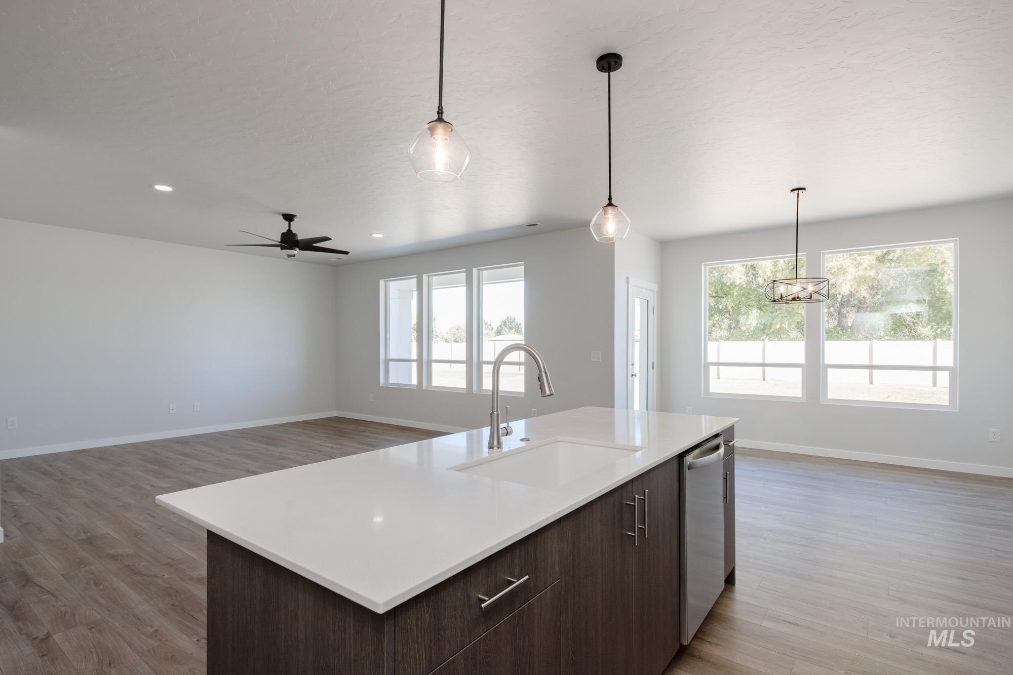 5304 Castleton Avenue Nampa, ID 83686 - Photo 25 of 25 Kitchen featuring dark brown cabinetry, open floor plan, decorative light fixtures, light wood-type flooring, and recessed lighting