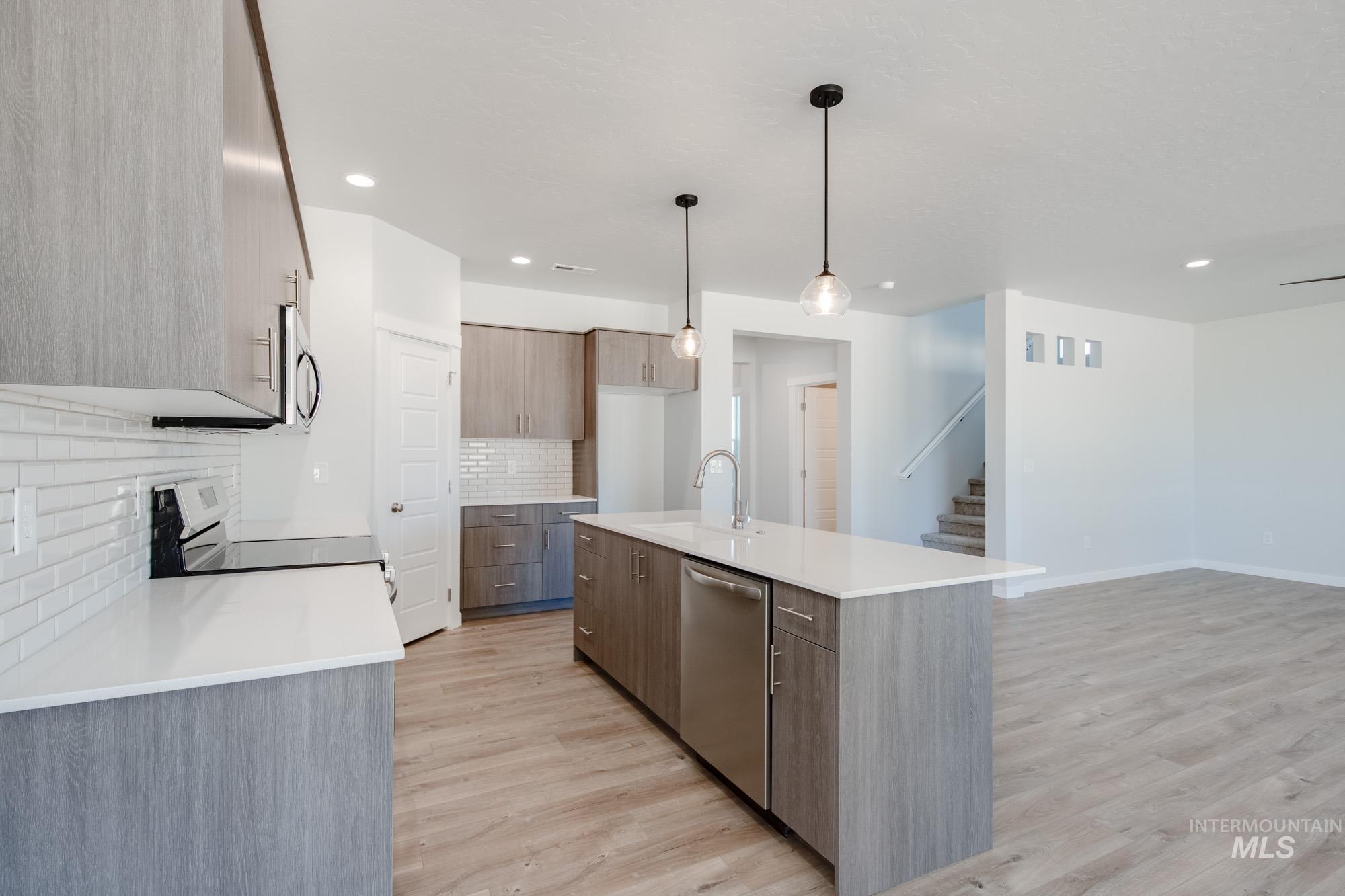 5304 Castleton Avenue Nampa, ID 83686 - Photo 9 of 25 Kitchen with decorative backsplash, modern cabinets, light stone counters, light wood finished floors, and recessed lighting