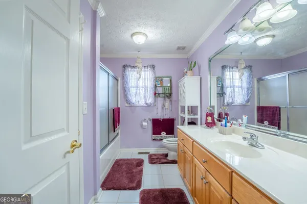 a bathroom with a sink toilet vanity and shower