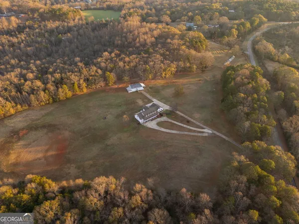 an aerial view of house with yard and mountain view in back