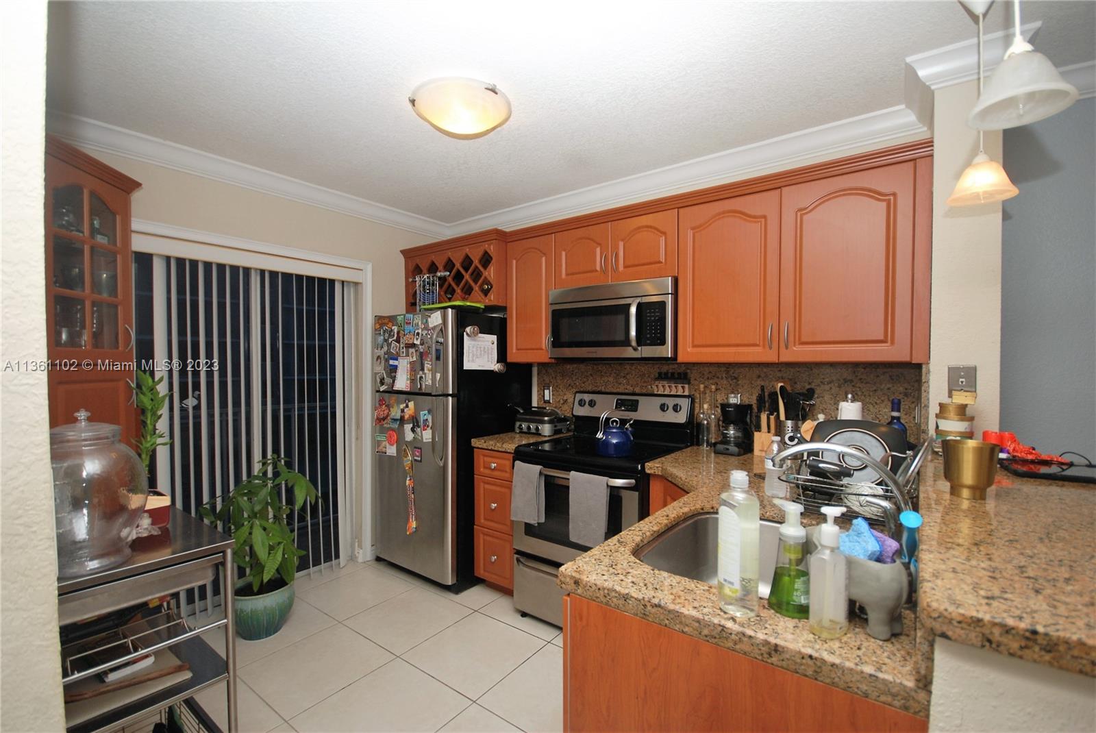 2575 Southwest 27th Avenue, Unit 409 Miami, FL 33133 - Photo 5 of 18 a kitchen with stainless steel appliances granite countertop a refrigerator and a stove top oven
