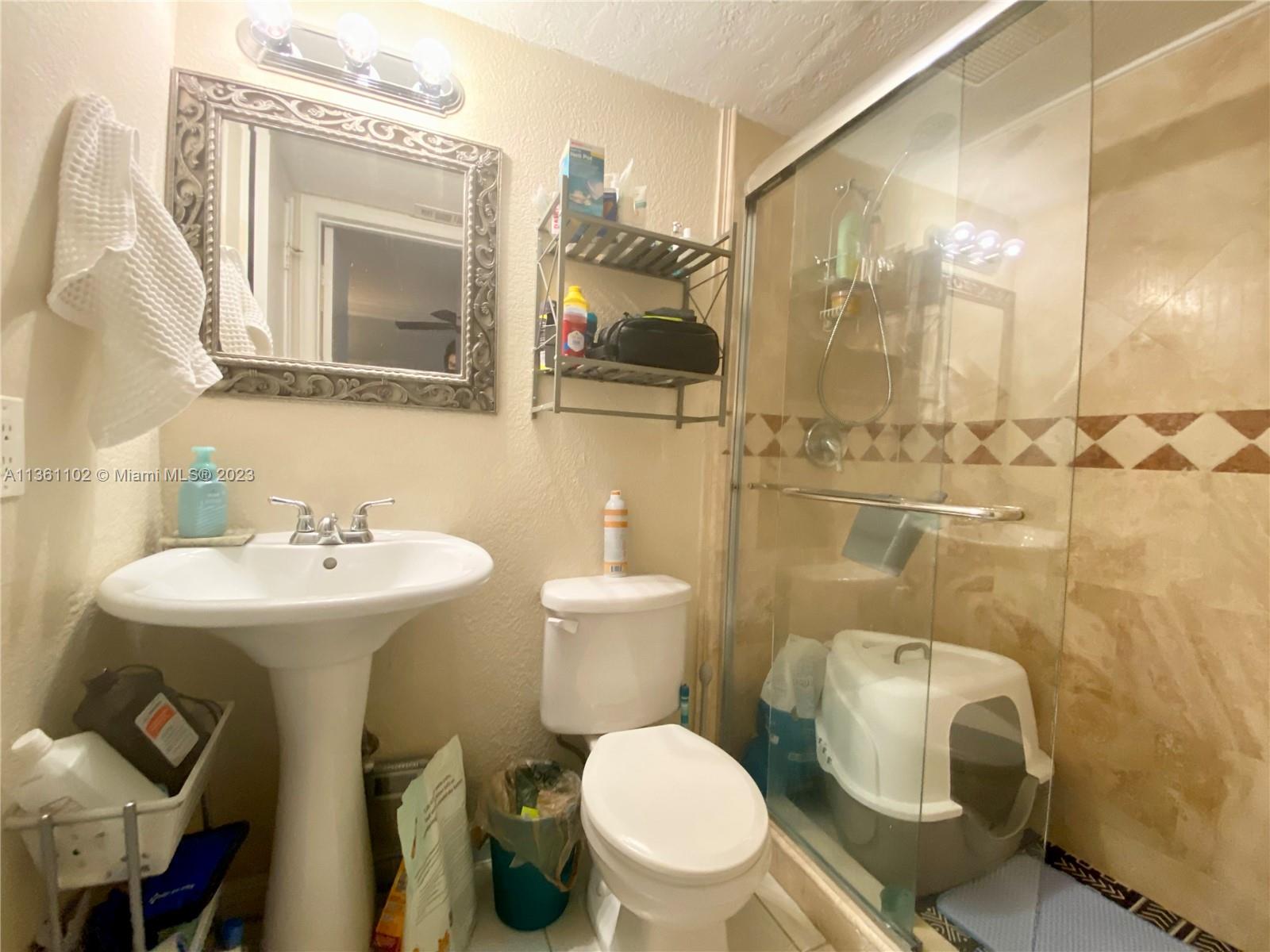 2575 Southwest 27th Avenue, Unit 409 Miami, FL 33133 - Photo 10 of 18 a bathroom with a bathtub shower sink mirror and toilet