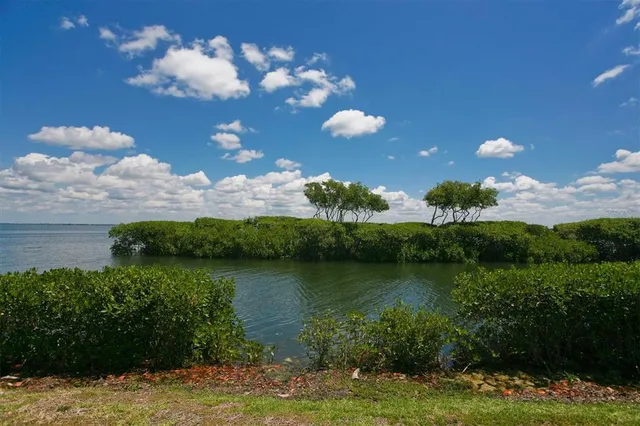 a view of a lake with lawn chairs