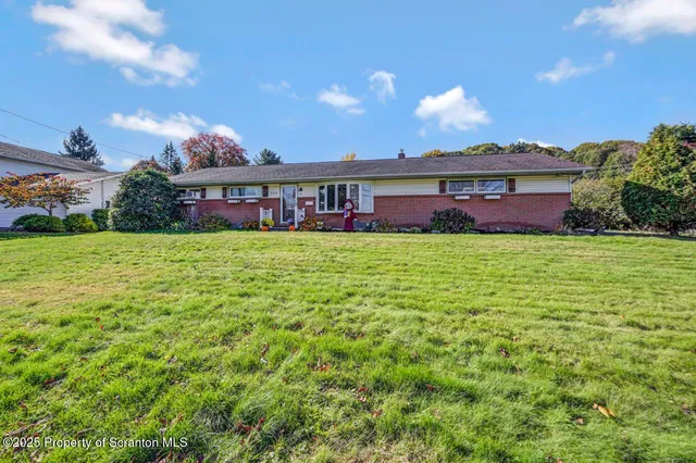 a view of a house with a yard and a tree