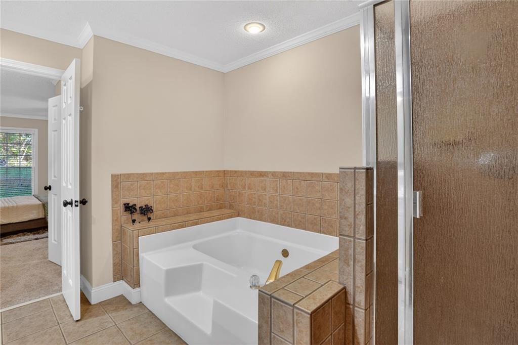 90 Hoglen Drive Covington, GA 30016 - Photo 18 of 28 a bathroom with a bathtub and a shower