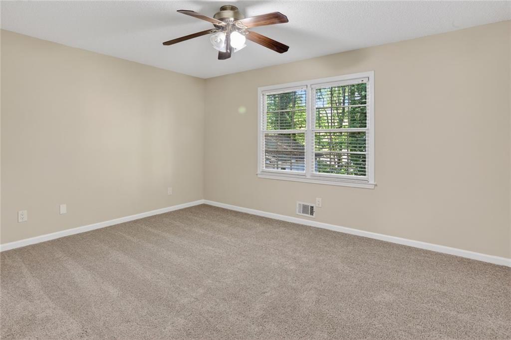 90 Hoglen Drive Covington, GA 30016 - Photo 21 of 28 an empty room with a window and a fan