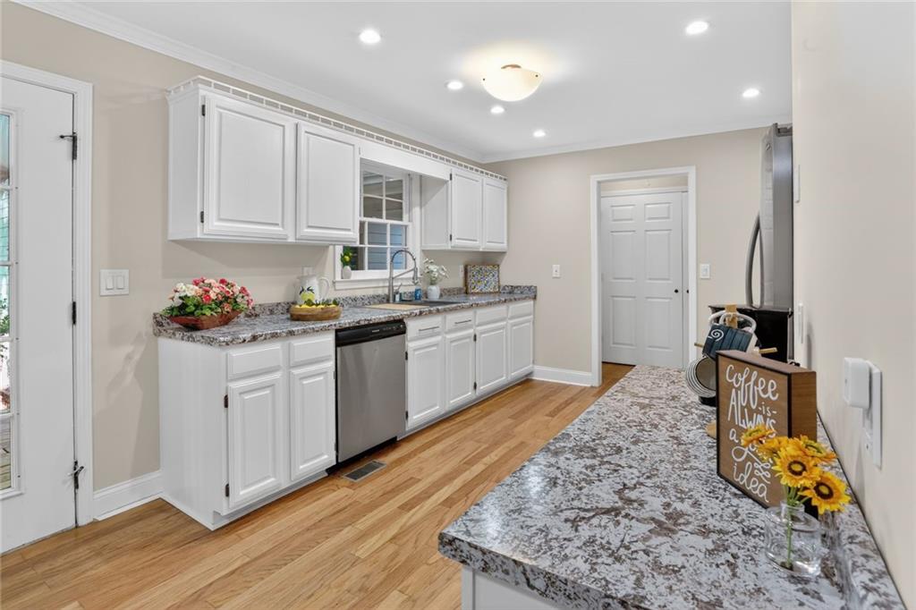 90 Hoglen Drive Covington, GA 30016 - Photo 10 of 28 a kitchen with stainless steel appliances granite countertop a sink stove and white cabinets