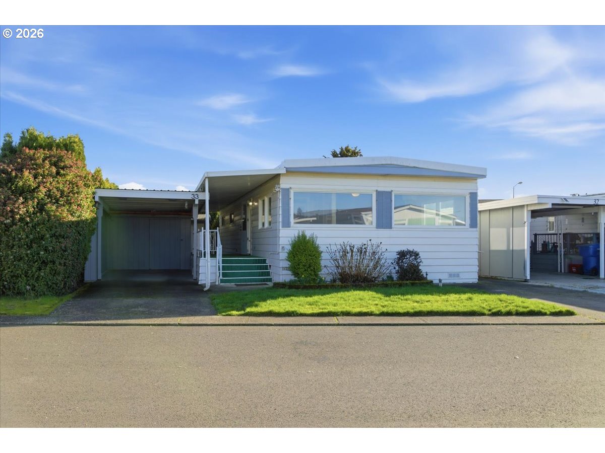5422 Portland Road Northeast, Unit 33 Salem, OR 97305 - Photo 1 of 28 a front view of a house with a garden and yard