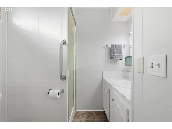 a bathroom with a granite countertop sink mirror and shower