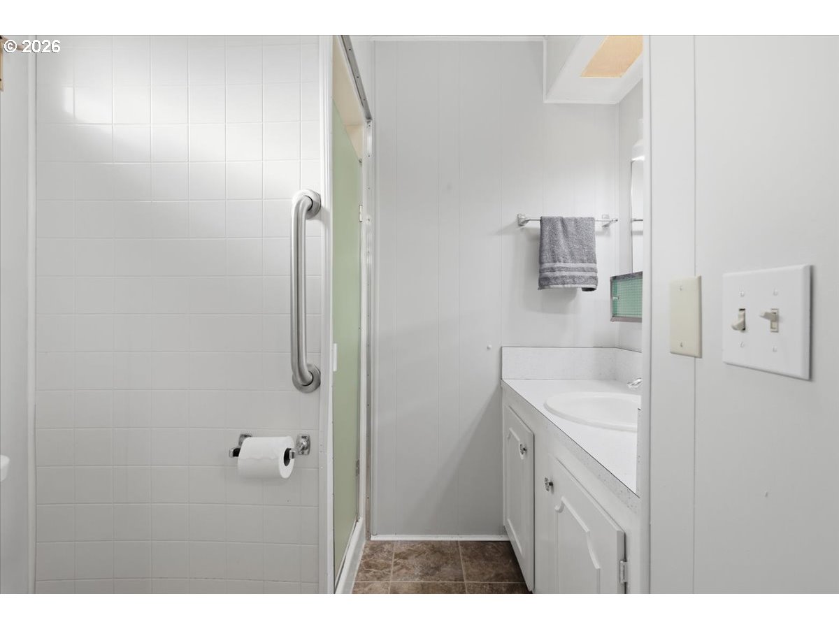 5422 Portland Road Northeast, Unit 33 Salem, OR 97305 - Photo 16 of 28 a bathroom with a granite countertop sink mirror and shower