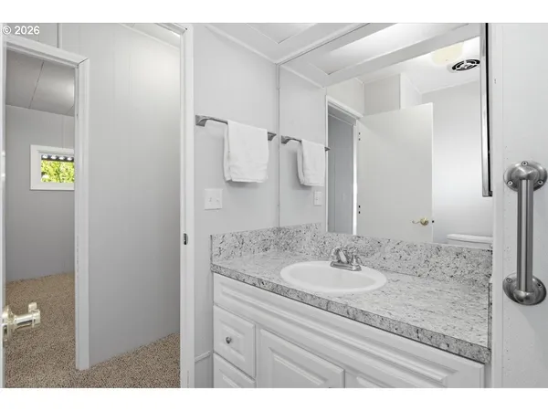 a bathroom with a granite countertop sink and a mirror