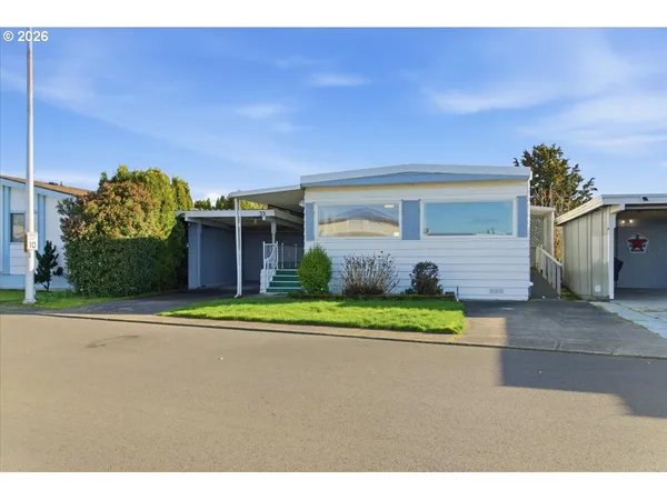 a front view of a house with a yard and trees