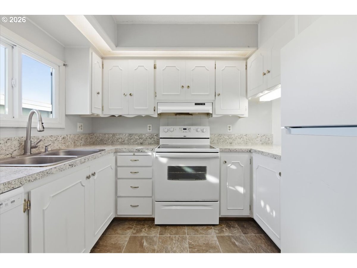 5422 Portland Road Northeast, Unit 33 Salem, OR 97305 - Photo 8 of 28 a kitchen with granite countertop white cabinets and white appliances