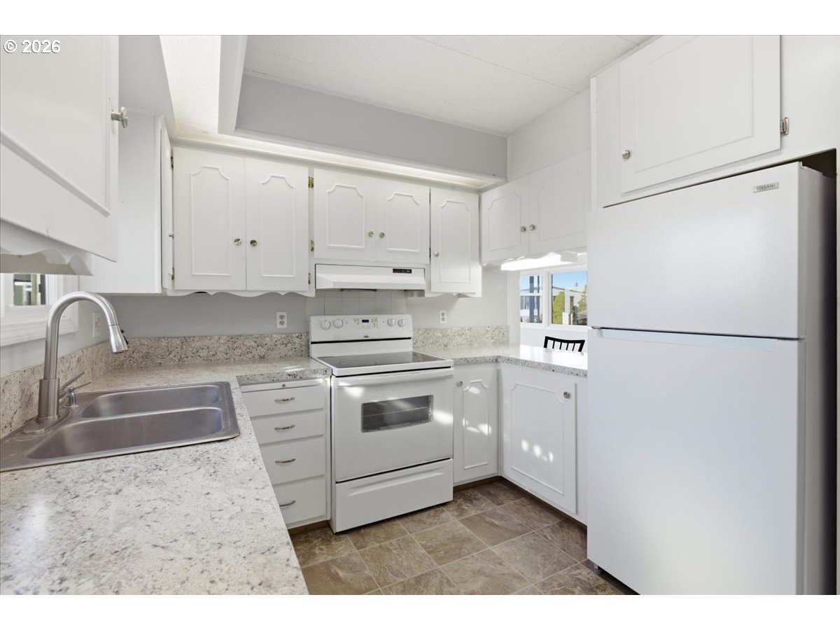 5422 Portland Road Northeast, Unit 33 Salem, OR 97305 - Photo 9 of 28 a kitchen with granite countertop white cabinets and white appliances