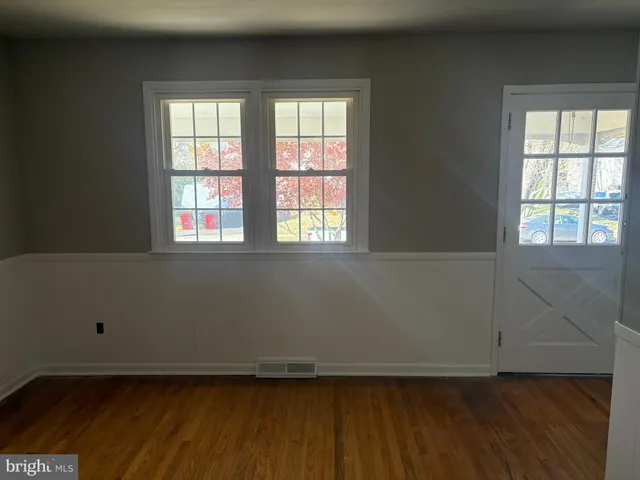 a view of a hallway with wooden floor and a cabinet