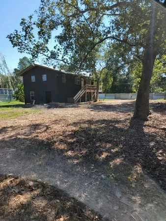a backyard of a house with large trees and a yard